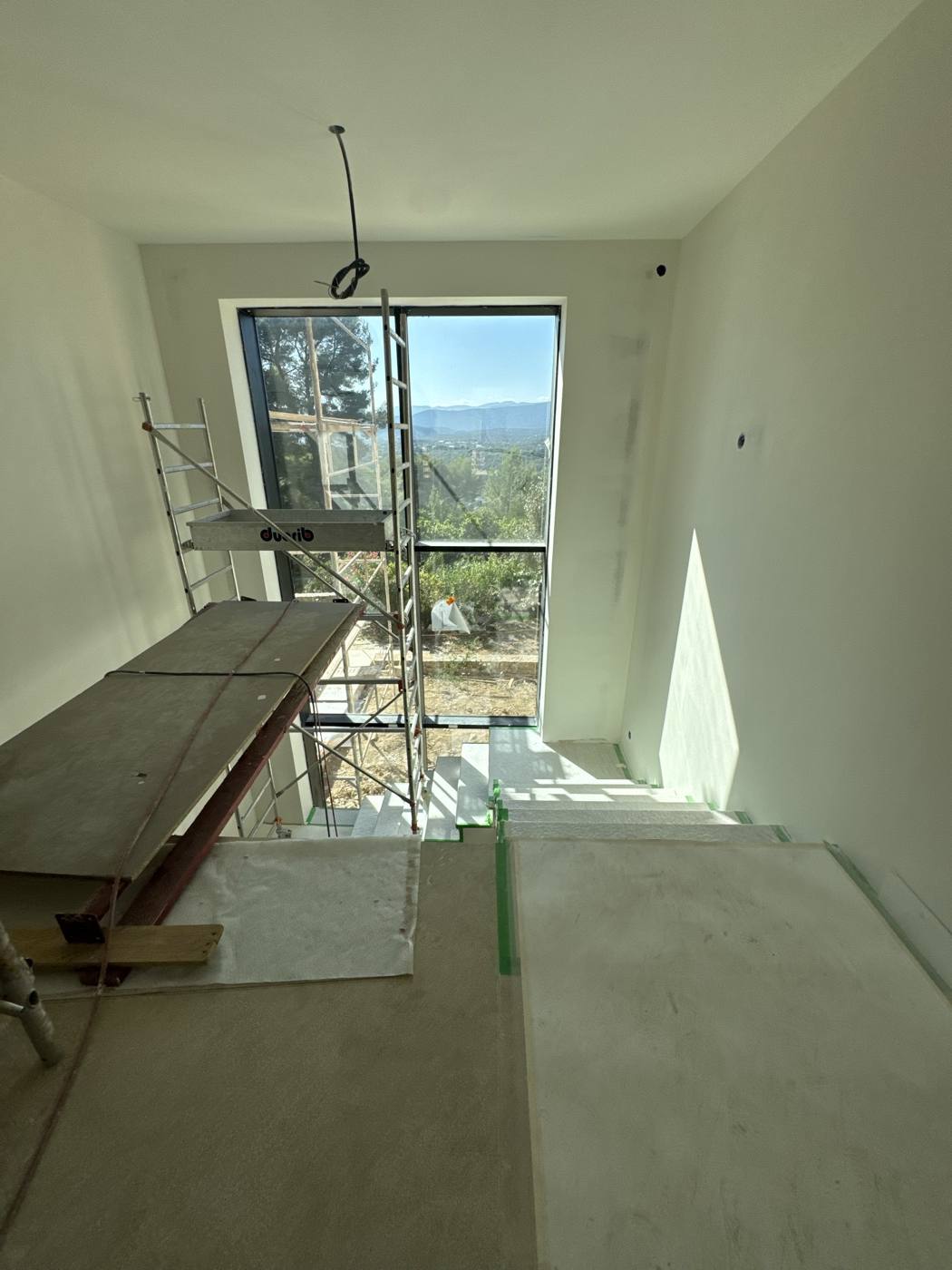 Cage d'escalier en chantier avec vue sur les collines niçoises