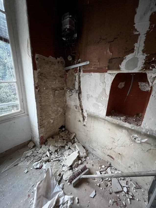 Petite salle de bain en cours de démolition, murs mis à nu