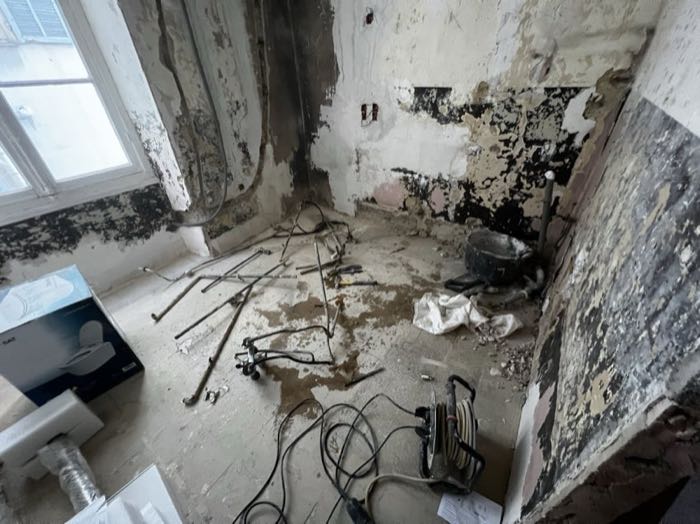 Grande salle de bain en cours de démolition, radiateur déposé