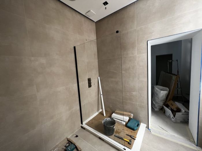 Grande salle de bain, douche vitrée en cours d'installation