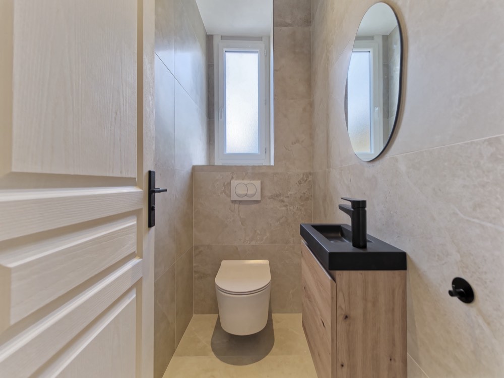 WC rénové, vasque noire et miroir ovale